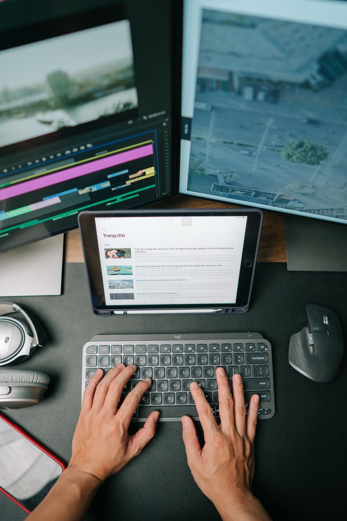 The Art of Drawing Readers In: Your attractive post title goes here Person typing on keyboard in modern workspace with multiple screens displaying content.