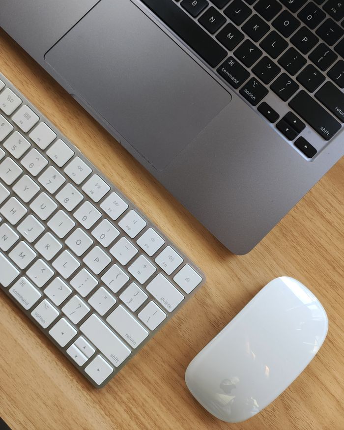 Mastering the First Impression: Your intriguing post title goes here Top view of a sleek workspace featuring a laptop, keyboard, and mouse on a wooden desk.